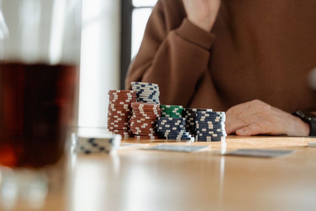 Casual poker scene with colorful poker chips and playing cards on a wooden table.