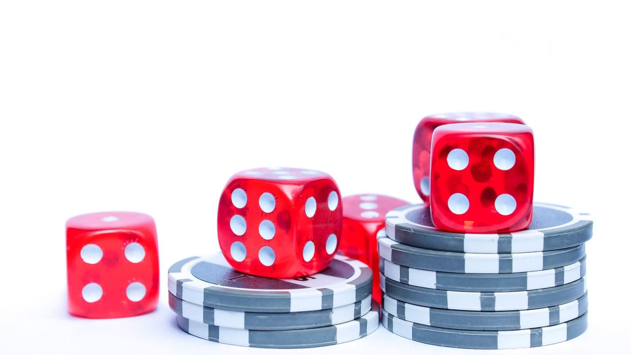 Vibrant red dice stacked with poker chips, ideal for gambling themes.